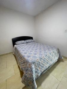 1 dormitorio con 1 cama en una habitación blanca en Apartamento para viajeros Aeropuerto Maiquetia en Catia La Mar