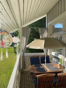 a patio table with an umbrella on a porch at Tahkontilhi in Kuopio