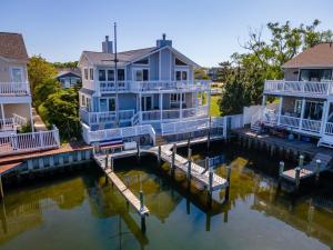 ein großes Haus am Wasser mit einem Dock in der Unterkunft Luxury Waterfront Villa Dock Game Room Sunset Views in Ocean City