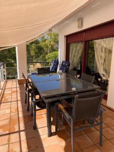 a ping pong table on a patio with chairs at Apartamentos Parque Botanico in Estepona