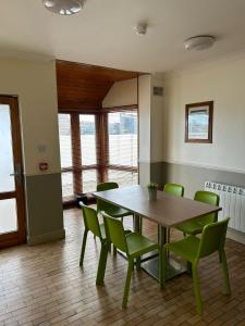 a dining room with a table and green chairs at Gogartys Temple Bar Apartments in Dublin