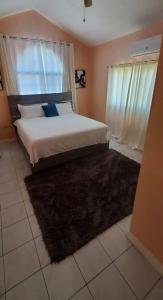 een slaapkamer met een bed en een groot raam bij Caribbean Estate Vacay Stay 3 in Portmore