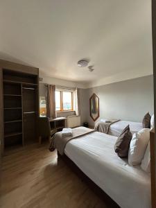 ダブリンにあるGogartys Temple Bar Apartmentsのベッド2台とデスクが備わるホテルルームです。