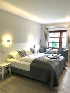 a bedroom with a large bed and a living room at Landhaus Nordstern Hotel garni in Utersum