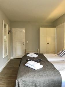 a bedroom with two beds and two towels on a bed at Landhaus Nordstern Hotel garni in Utersum