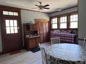 a dining room with a table and a ceiling fan at The Manor at Glen Jean Meadows in Oak Hill