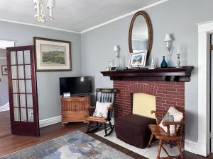 a living room with a fireplace and a tv at The Manor at Glen Jean Meadows in Oak Hill