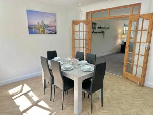 uma sala de jantar com mesa e cadeiras em Long-Term Comfort - Modern 3BR Retreat with Free Parking & WiFi em Enfield Lock