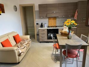 a kitchen with a couch and a table with flowers on it at Casa al mare in Lascari