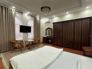 1 dormitorio con cama, mesa y TV en Hello Dushanbe Hostel en Dusambé