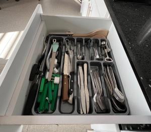 a drawer full of utensils in a white drawer at Snowy Lodge, fully airconditioned & luxurious apartments in Paramaribo