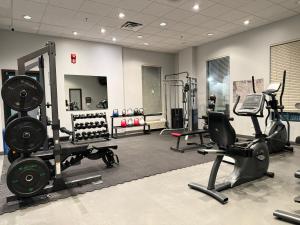 a gym with several treadmills and machines in a room at Divya Sutra Plaza and Conference Centre Calgary Airport in Calgary