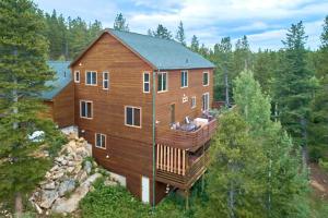 a large wooden house in the middle of a forest at Coyote Cottage Retreat Hot Tub Deck Mtn Views in Black Hawk