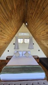 ein großes Bett in einem Zimmer mit Holzdecke in der Unterkunft Mirante das Cabanas in Guarapari