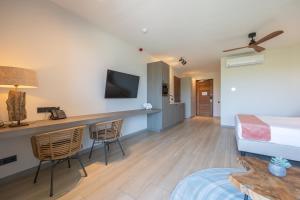 Habitación de hotel con cama, escritorio y sillas en Dolphin Suites & Wellness Curacao en Willemstad