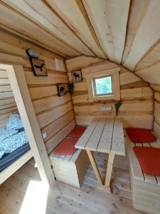 einen Innenblick auf eine Holzhütte mit einem Bett und einer Bank in der Unterkunft Camping & Pension Au an der Donau in Au an der Donau
