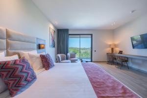 Duży pokój hotelowy z dużym łóżkiem i biurkiem w obiekcie Dolphin Suites & Wellness Curacao w mieście Willemstad