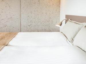 - une chambre avec un lit blanc et une lampe dans l'établissement Hotel Føroyar, à Tórshavn