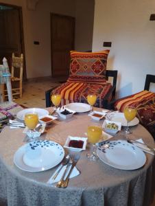 a table with plates of food and wine glasses on it at RIAD IDAR ouirgane in Ouirgane