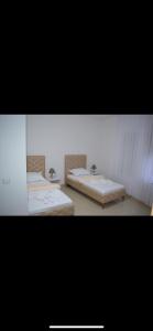 2 Betten in einem Zimmer mit 2 Waschbecken in der Unterkunft Hotel Palma in Dragash