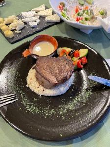 um prato de alimentos com carne e legumes sobre uma mesa em Hotel Palma em Dragash