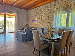 ein Esszimmer mit einem Tisch und einem Sofa in der Unterkunft Flamingo - House with private pool in Gornji Seget