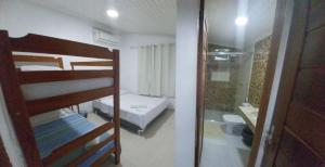 a bedroom with bunk beds and a bathroom with a shower at Pousada Muiraquitã Parintins in Parintins