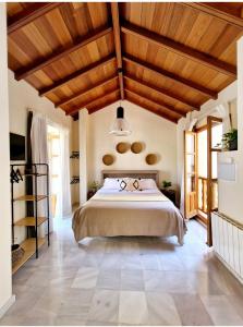 um quarto com uma cama grande e tectos em madeira em Apartamentos VITA CENTER em Granada