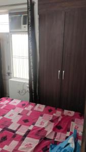 um quarto com uma cama com uma colcha em Bagpacker Stay em Faridabad