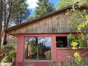 un cobertizo rojo con una gran ventana en Cabaña Casa Tetelhue, en Colliguay