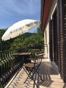 een tafel en stoelen op een balkon met een parasol bij Apartment Cimbora in Koper