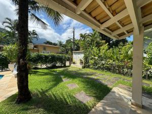 a backyard with a palm tree and a house at Casa com piscina privativa a 100m da Praia de Paúba in São Sebastião