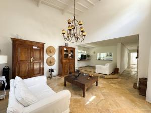 a living room with a white couch and a chandelier at Casa com piscina privativa a 100m da Praia de Paúba in São Sebastião