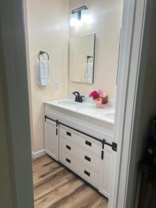une salle de bain avec un lavabo blanc et un miroir dans l'établissement Cottage style home close to golfing and lake, à Whispering Pines 17 autres photos