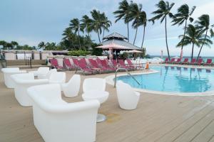 una piscina en el complejo con sillas blancas y una piscina en Oceanview Apartment on the beach 123 en Miami Beach