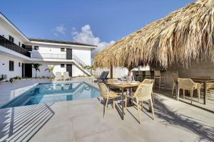 a patio with a table and chairs next to a pool at Villa Valena Apartment 9 with Cooling Pool in Kralendijk