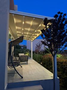 a patio with a bench and a tree at night at Vilë në Palasë in Palasë