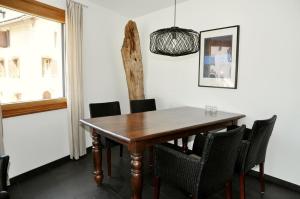 een eetkamer met een houten tafel en stoelen bij Craista 5 in Scuol