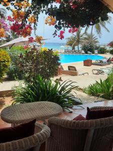 a patio with a table and chairs and a pool at Porto Antigo 2 Beach Club in Santa Maria