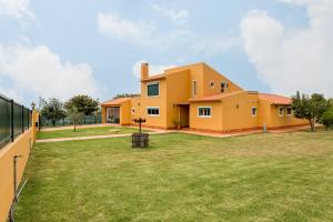 a yellow house with a large yard at Casa do Vale in Chelreira