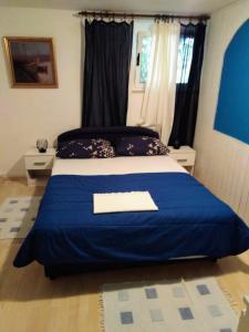 1 dormitorio azul y blanco con 1 cama con manta azul en Leo, en Makarska