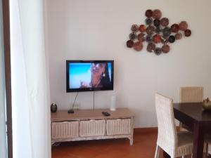 a living room with a television on a white wall at Porto Antigo 2 Beach Club in Santa Maria