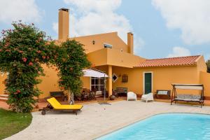 a villa with a swimming pool and a house at Casa do Vale in Chelreira