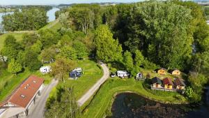 eine Luftansicht eines Hauses mit einer Straße, die zu einem See führt in der Unterkunft Camping & Pension Au an der Donau in Au an der Donau