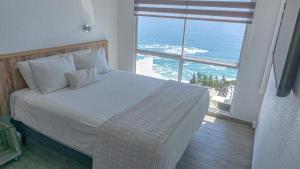 a bedroom with a bed with a view of the ocean at Dei Templi Hotel in Viña del Mar