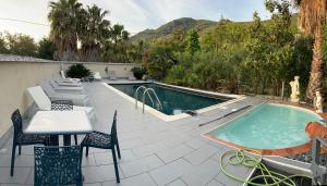 une terrasse avec une table et des chaises ainsi qu'une piscine dans l'établissement maison 5 personnes au calme avec jardin et piscine, à Barbaggio