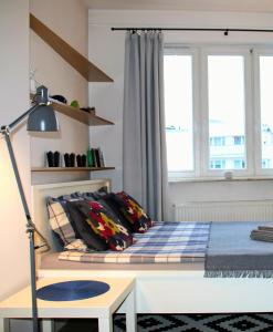 a bedroom with a bed with a desk and a window at Apartament blisko Centrum in Warsaw