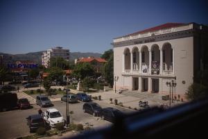 a building with cars parked in a parking lot at Corner Hostel in Shkodër