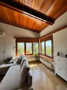 a living room with a large couch and windows at Lisa's country house in Lefkandi Chalkidas
