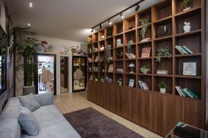 a living room with a couch and shelves with plants at Corner Hostel in Shkodër